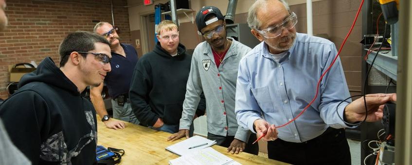 Faculty and students test equipment in lab.